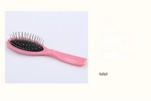 Close-up of pink air cushion hairbrush with metal bristles for scalp massage