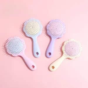 Détail de quatre brosses à cheveux à coussin d'air en forme de fleur aux tons pastel