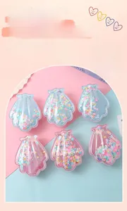 Détail de brosses à cheveux en forme de coquillage avec paillettes mobiles colorées