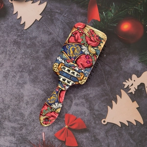 Detail showing colorful horse illustration and floral pattern on a paddle hairbrush back