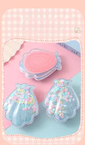 Détail de brosses à cheveux en forme de coquillage avec paillettes et picots démêlants