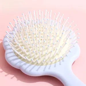 Détail des poils de massage à bout rond sur une brosse à cheveux en forme de fleur