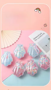Détail de brosses à cheveux en forme de coquillage avec paillettes et effet sable mouvant