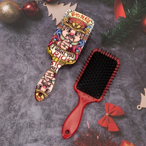 Détail de brosse à cheveux à coussin d'air rouge avec motif de dieu de la fortune