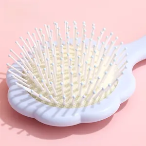 Détail de la brosse à coussin d'air en forme de fleur avec cadre violet et picots blancs