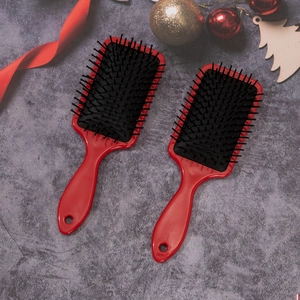 Set of two red anti-static massage hairbrushes with festive Christmas background