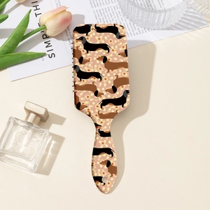 Détail de l'imprimé teckel et fleurs sur le dos d'une brosse à cheveux rose