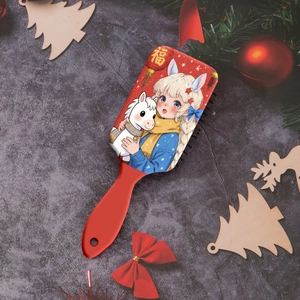 Gros plan d'une brosse à cheveux rouge avec motif de fille et poney dans un décor festif
