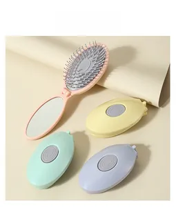 Detail view of portable folding hairbrush with mirror in macaron colors and massage bristles