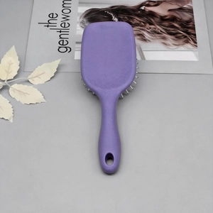 Macro detail of purple air cushion hairbrush with silver bristles and matte texture