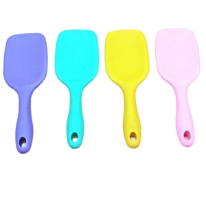 Set of four colorful mini hairbrushes with air cushions in purple, green, yellow, and pink