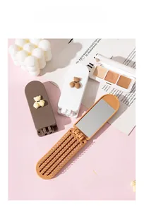 Detail of portable foldable hairbrush with built-in rectangular mirror and cute bear design