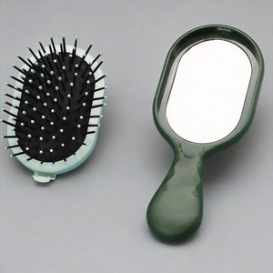 Detail of portable air cushion massage hairbrush and hand mirror set in deep forest green