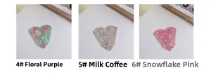 Detailed shot of heart-shaped acetate hair combs in floral purple, latte, and snowflake pink