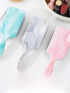 Detailed view of marble pattern hair brushes with gold veins and flexible air cushion