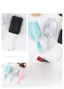 Detail of marble pattern cushion hairbrush showing fine bristles and ergonomic handle