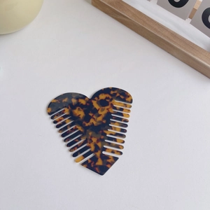 Detailed view of heart-shaped anti-static hair comb with classic tortoise shell pattern