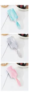 Detail of marble pattern cushion hair brushes in blue, white and pink with hanging hole