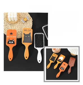 Detail von Halloween Haarbürsten mit schwarzen Katzen und Spinnenmustern auf orangefarbener Basis