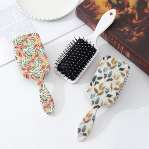 Three minimalist air cushion hairbrushes featuring tropical leaf and botanical prints
