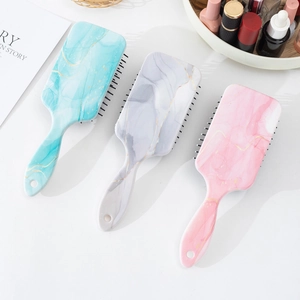 Marble pattern air cushion hairbrushes in blue, grey, and pink with anti-static bristles