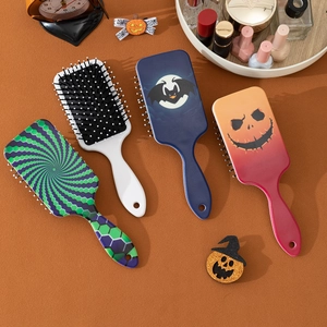 Brosses à cheveux d'Halloween avec motifs de citrouilles et de chauves-souris sur la table