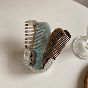 Peignes à cheveux élégants en acétate motifs écaille et marbre dans un verre