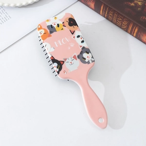 Detail of pink air cushion hairbrush featuring cute cartoon cat patterns and MEOW text
