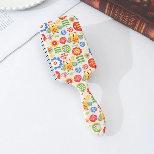 Detail of floral owl print air cushion hair brush with ergonomic handle and hanging hole