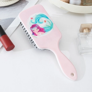 Detailed view of pink mermaid paddle brush with soft bristles and cute cartoon artwork