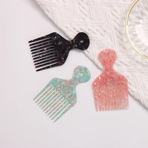 Three acetate hair combs with colorful marble patterns and wide teeth in a flat lay view