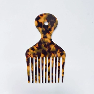 Macro detail of tortoiseshell wide-tooth comb with smooth finish and circular handle