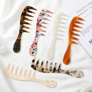 Set of wide-tooth acetate hair combs in tortoise shell and marble patterns on white silk