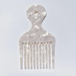 Detail of white marble textured acetate hair comb with wide teeth and a circular handle