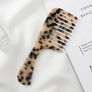 Macro detail of wide-tooth acetate hair comb with elegant tortoiseshell marble patterns