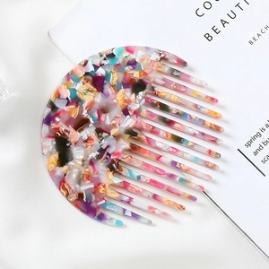 Detail of colorful marble pattern acetate hair comb with smooth teeth on white background