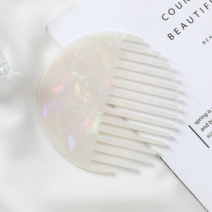 Detail of round marble texture hair comb made of acetate material on white silk