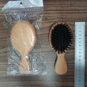 Brosse à cheveux massante en bois écologique avec poils noirs, mesure montrée sur bois naturel