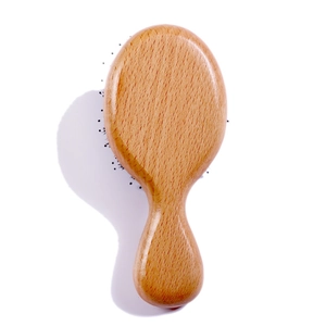 Vue détaillée d'une brosse de massage ergonomique en bois avec veinage naturel poli