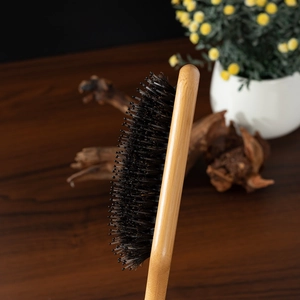 Detailed side view of wooden paddle brush featuring natural boar bristles and nylon pins