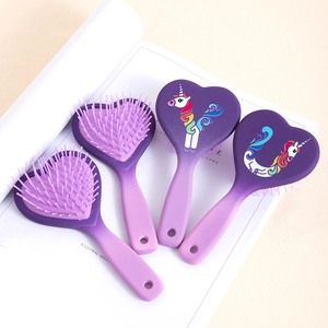 Dettaglio di quattro spazzole a cuore con stampe di unicorno e finitura viola sfumata