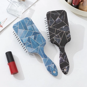 Vue détaillée de brosses à cheveux aux motifs marbrés modernes avec trou de suspension