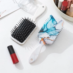 Set of two paddle hair brushes featuring elegant blue and orange marble texture prints