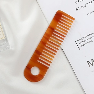 Close-up of tortoise shell acetate wide tooth comb with a convenient hanging hole