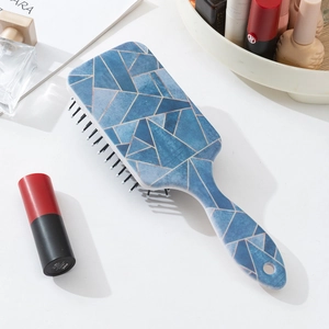 Détail de la brosse de massage motif marbre bleu avec trou de suspension sur coiffeuse