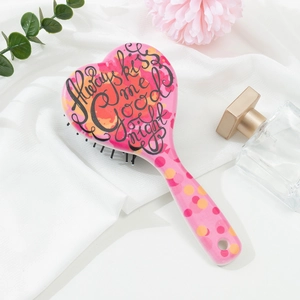 Brosse à cheveux rose en forme de cœur avec texte sur fond de tissu blanc élégant