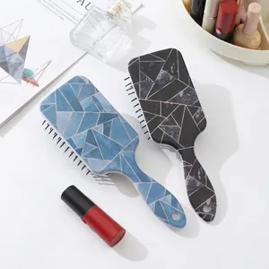 Brosses à cheveux à motif marbre bleu et noir avec coussin de massage sur table