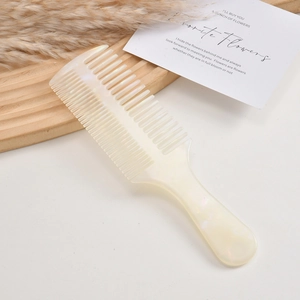 Close-up of double-sided acetate hair comb with wide and fine teeth in pearlescent finish