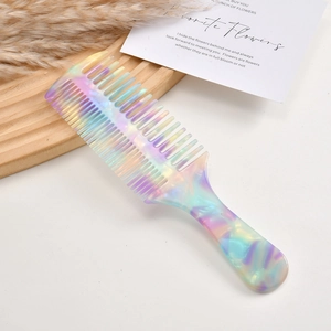 Macro detail of iridescent acetate comb with dual-tooth design on a rustic wooden tray