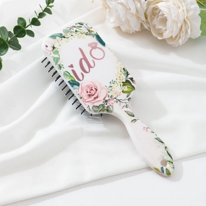 Detail of white air cushion hairbrush with pink 'i do' text and rose floral print